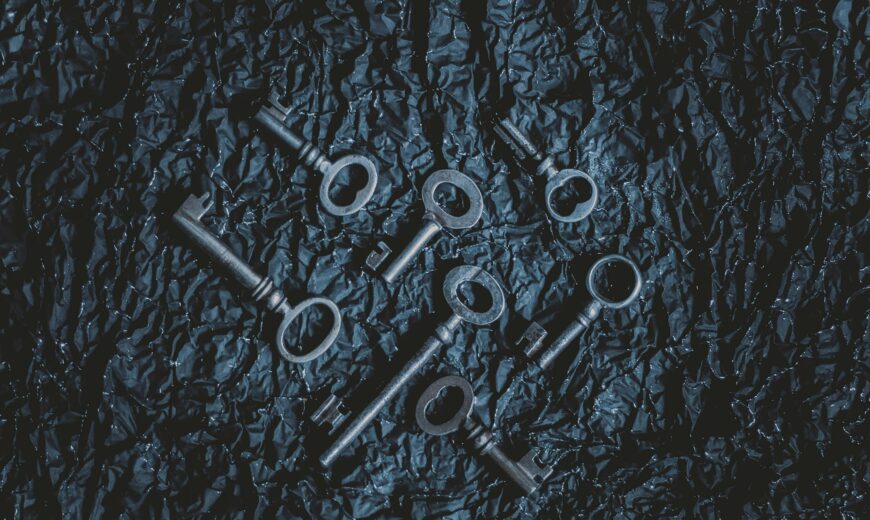 A ring of old iron house keys on a wooden table